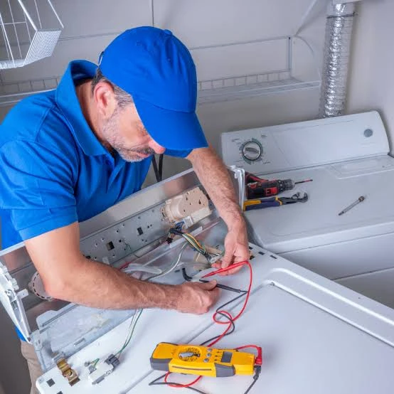 Technician testing the wiring of a top-loading laundry appliance