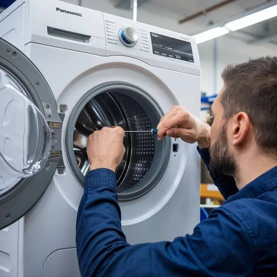 Technician inspecting the drum of a front-loading washing machine